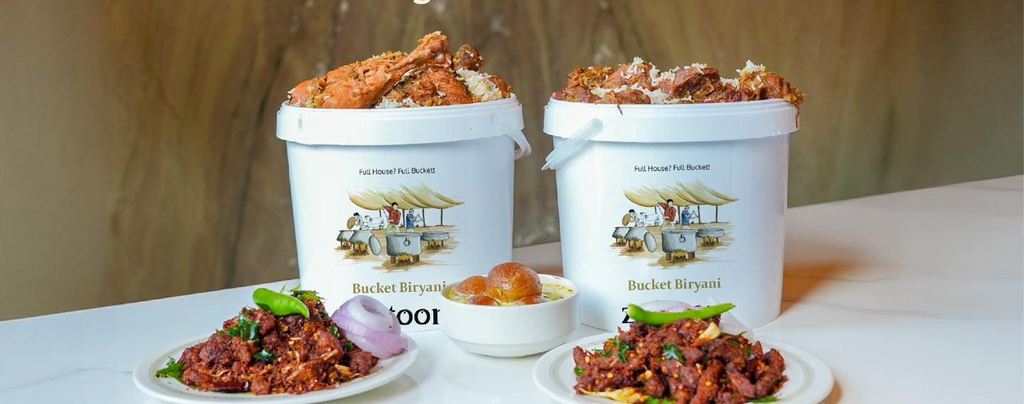 Bucket Malabar biryani with eri pori sides and saffron rabadi